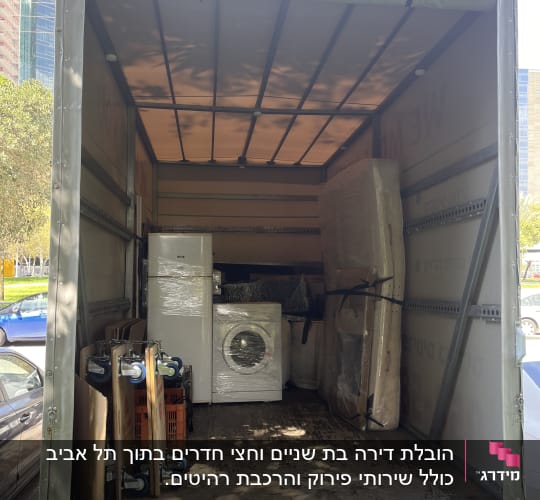 משאית פתוחה עם מכונת כביסה וציוד ארוז להובלה